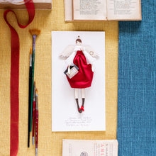 Carica l'immagine nel visualizzatore di Gallery, ANGELO della LAUREA in legno di pioppo dipinto e vestito a mano, abito di cotone rosso con maniche in nastro color tortora. Coccinella e libricini sagomati in carta; piccolo fiocco di raso rosso sulla scarpetta.