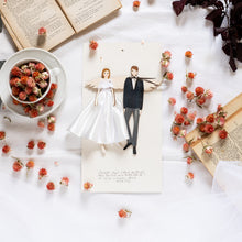 Load image into Gallery viewer, ANGELO degli SPOSI, struttura stampata su legno e dettagli dipinti a mano, abito in raso e pizzo di cotone bianco, fiocco in lurex per la sposa, papillon nero in raso per lo sposo.