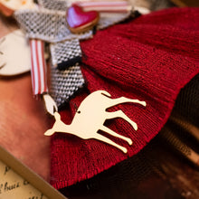 Carica l'immagine nel visualizzatore di Gallery, Dettaglio dell'Angelo del CERVO ROSSO in legno di pioppo, dipinto e vestito a mano, abito in stoffa  sottogonna in tulle, gonna rossa e top bianco/nero jacquard, camicia in cotonina a righe. Ricchissimo di accessori.