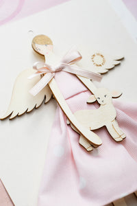 Dettaglio dell'ANGELO della BIMBA GRANDE, struttura in legno di pioppo dipinta e vestita a mano, abito in cotone rosa a poi e fiocco in raso; piccolo accessorio in legno a forma di agnello.