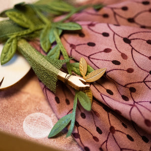 Dettaglio dell'Angelo della MONGOLFIERA in legno di pioppo, dipinto e vestito a mano, sottogonna di tulle, gonna di cotone rosa scuro, top verde, sciarpa a foglie. Ricchissimo di accessori.