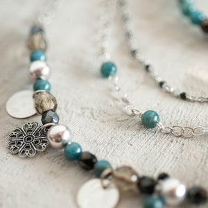Dettaglio del bracciale DOPPIO a due fili, realizzato con catene color argento, perle di apatite grezzo scuro e catena a rosario con cristalli neri.