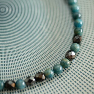 Dettaglio della collana GIROCOLLO PERLE realizzata con perle di apatite grezzo scuro e cristalli color rame antico.