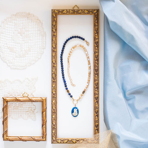 Collana CAMEO BLU con charm a forma di cammeo in resina color blu e avorio, perle di madreperla cappuccino e lapislazzulo tinto blu satinato.