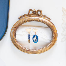 Load image into Gallery viewer, Orecchini CAMEO BLU asimmetrici con charm a forma di cammeo in resina color blu e avorio, perle di lapislazzulo tinto blu satinato e charm dorato.
