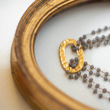 Load image into Gallery viewer, Dettaglio del bracciale FILI realizzato con fili di cristalli grigi montati a rosario ed un elemento centrale tondo dorato.
