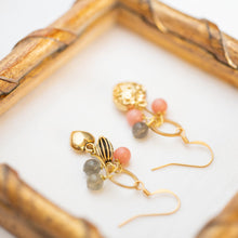 Load image into Gallery viewer, Dettaglio degli orecchini CUORI con pendenti a ciuffo, cuori dorati e pietre dure: aulite rosa e labradorite.
