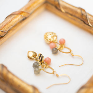 Dettaglio degli orecchini CUORI con pendenti a ciuffo, cuori dorati e pietre dure: aulite rosa e labradorite.