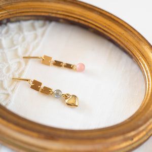 Dettaglio degli orecchini QUADRI asimmetrici con cuore dorato e pietre dure: aulite rosa e labradorite, piastrine placcate oro 24k.