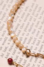 Load image into Gallery viewer, Dettaglio del bracciale FOGLIA e FIORE a doppio giro con un elemento metallico a forma di foglia, charm pendente a forma di fiore con zirconi incastonati e perline di madreperla cappuccino
